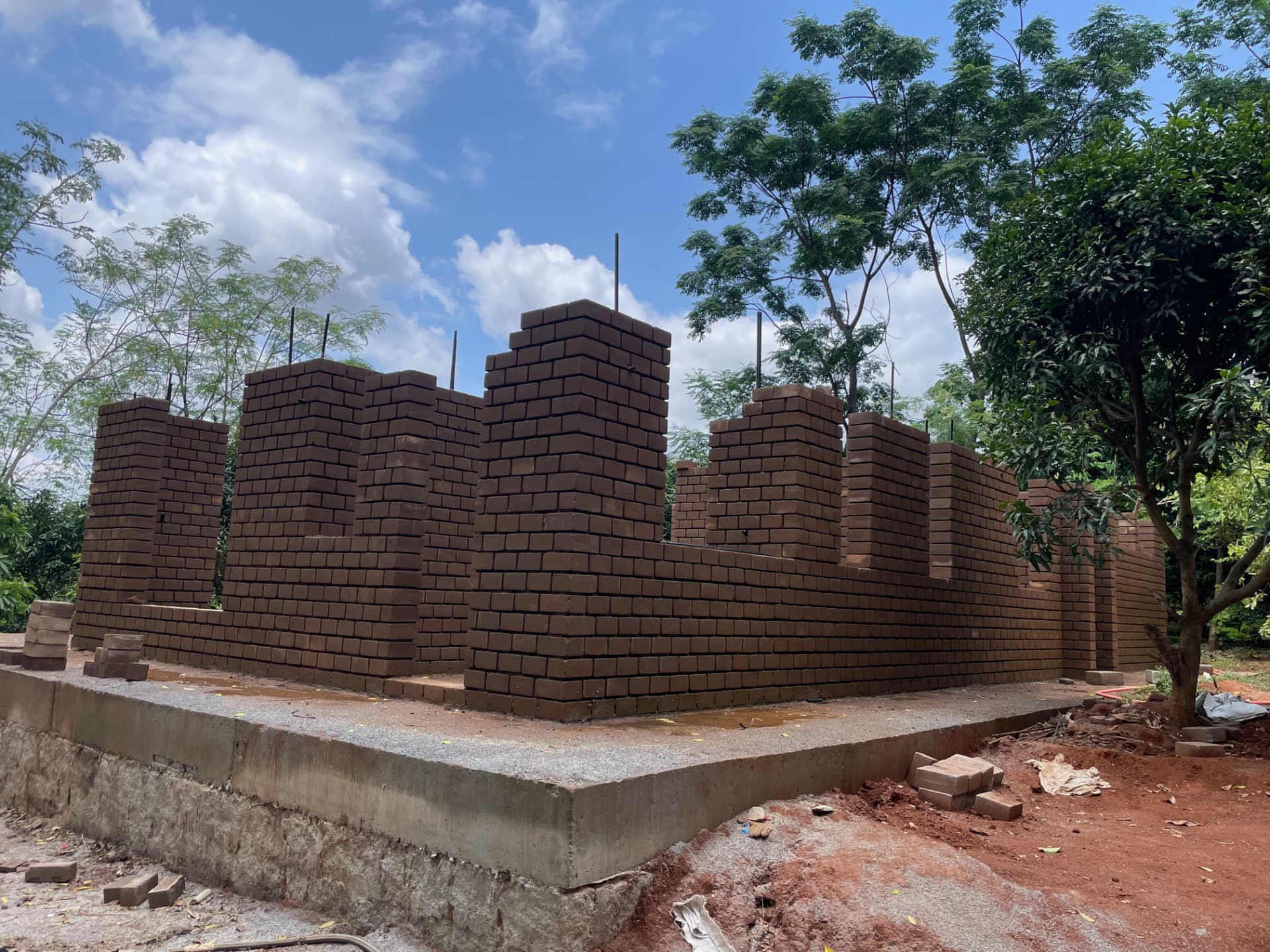 Brick pillars and walls of the farmhouse standing against a bright blue sky